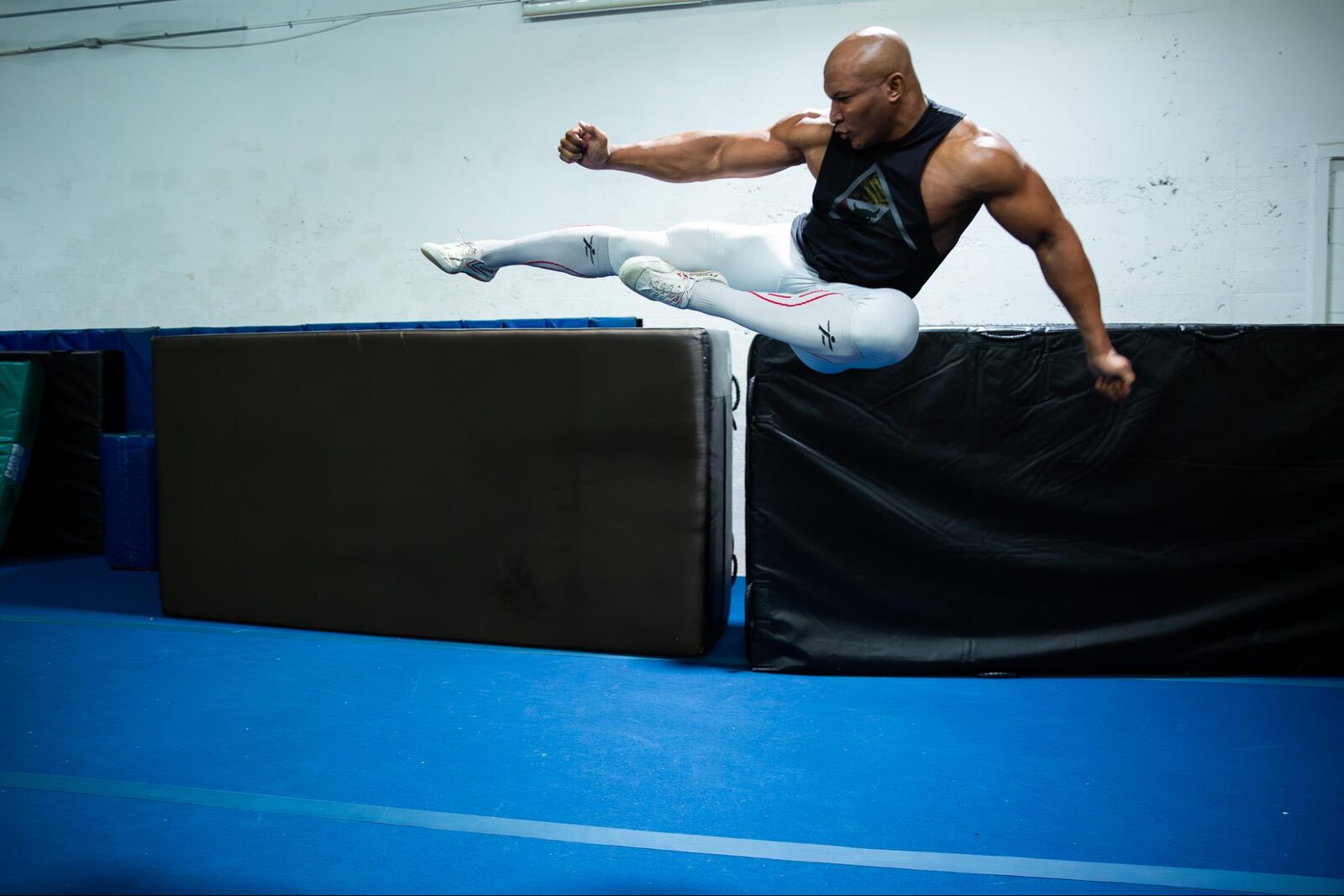 Stunt performer Gary Peebles mid-air during a jump kick at a stunt gym in Atlanta